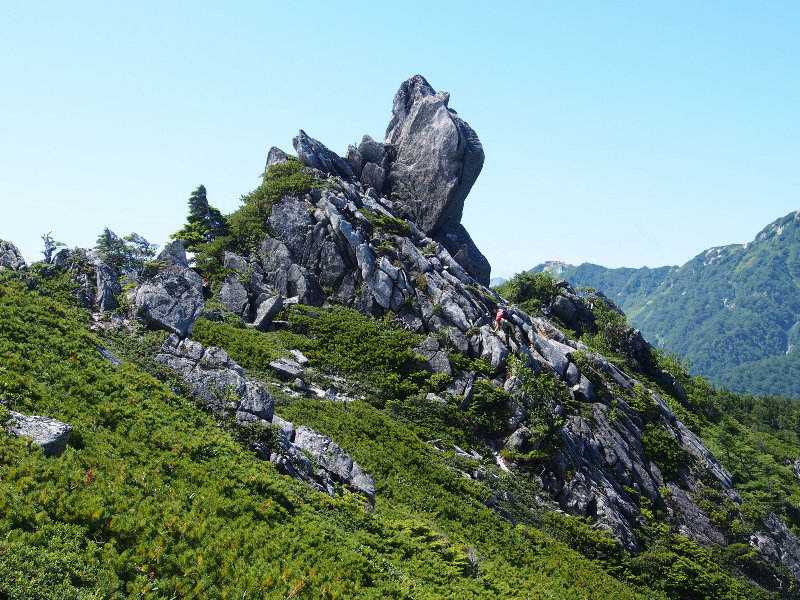 右側に傾斜した岩場は、登山者がいる辺りを通過
