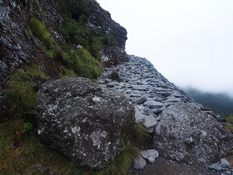 黒い岩塊の基部を巻くように付けられた登山道は、数多くの石が整然と並べられ、良く整備されています。