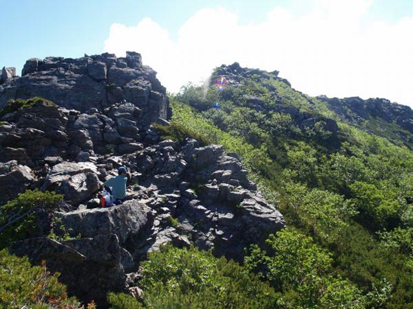 前の写真の岩を登った所から撮影。岩稜の登りですが鎖場にはなっていません。中央のピークの先に栗沢山山頂があります。