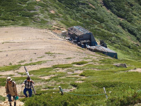 根石岳中腹より見下ろす。　白砂新道指導標設置のために山びこ荘、本沢温泉の方達が１５kgほどの重さがあるポールを担ぎあげています。