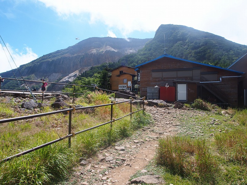 (標高 2,440m)夏沢峠に建つ「山彦荘」と「ヒュッテ夏沢」。後ろには、爆裂火口が迫力ある景観を作り出している「硫黄岳」。ヒュッテ夏沢の営業期間は短く、一般登山者は土日のみ宿泊可能です。それ以外は、学校登山の団体で貸切になります。