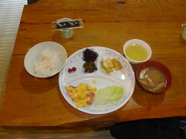 朝食。スクランブルエッグ、ハム、佃煮、納豆、のりなど。