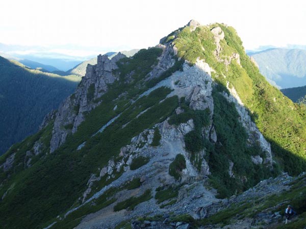 鞍部から少し登った所で天狗岩を振り返る。天狗岩のピークから少し下がった左側に登山道があるのがわかります。