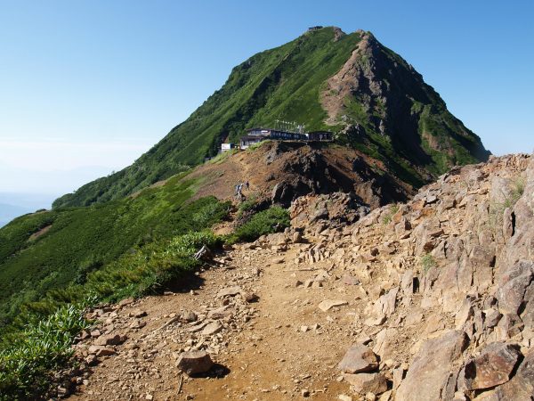 地蔵の頭から赤岳天望荘の先に赤岳を望む。右手方向には、これまで見えなかった富士山が中岳越しに姿を現しました。八ヶ岳の主稜線に上がると、いきなり強風に見舞われることもあります。