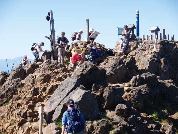 赤岳南峰頂上でくつろぐ登山者達。南アルプス、北アルプス、富士山など360度の展望です。山頂には赤岳神社が祀られています。、毎年6月第1週の日曜日正午から、ここで開山祭が執り行われます。
