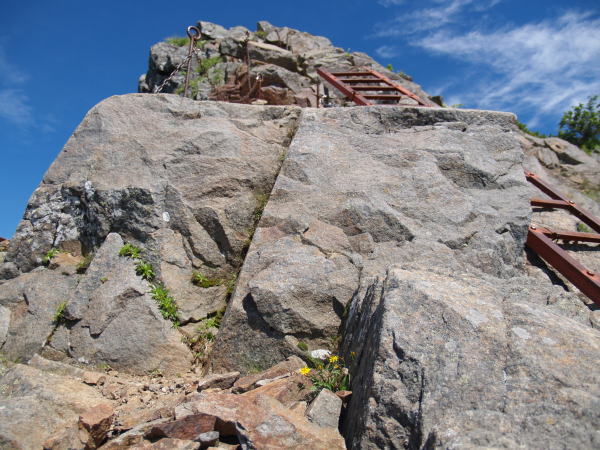 キレット縦走路の核心部　ルンゼの登りが終了した所に難所が出てきます。写真左上部の岩に隠れて全部は見えませんが鎖の一部が設置されているのが見えています。この鎖場の傾斜は７０度ほできついためか写真の様に梯子も併設されています。