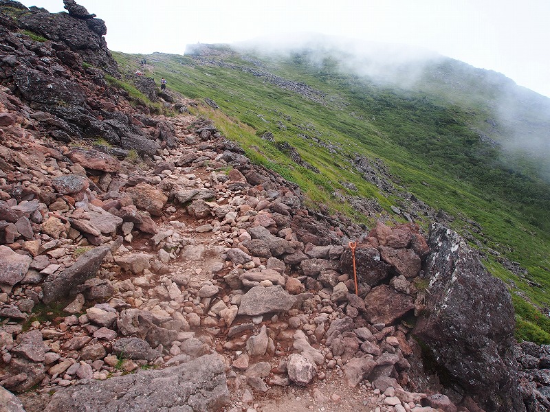 登山道が赤土の岩礫に変わる辺りまで登ると、「硫黄岳山頂」が見えてきました。ややガスが入って全容が掴めません。