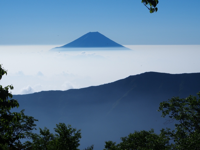 南東方向に目をやると霞の上に姿を現す富士山。手前の稜線を右手側にたどると笊ヶ岳が聳えています。