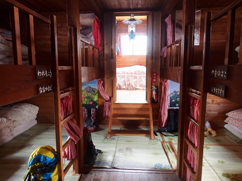 寝室は居間から階段を上がった先に2部屋あります。それぞれカイコ棚式の寝室です。混雑時は2枚の布団に3人で、約50人ほど収容可能です。