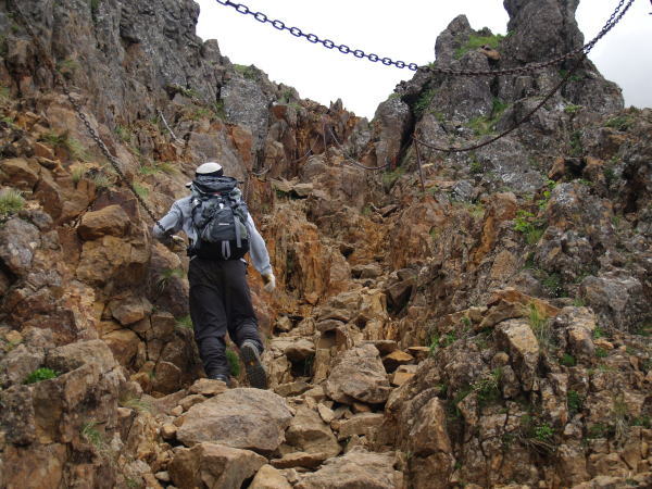 岩と岩の間を登って行きます。岩に囲まれている為、安心して登って行くことが出来ます。ここにも高い位置に鎖が設置されています。