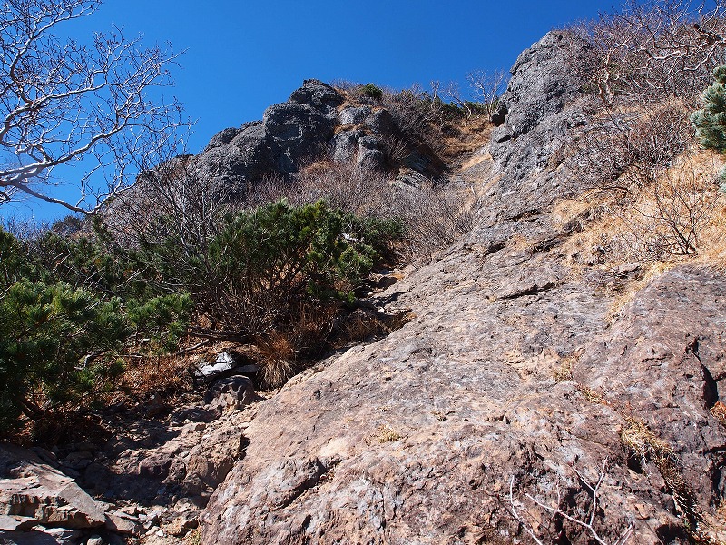 岩壁の中腹まで登り、左に巻いた所が鎖場です。さほどの傾斜はないので高度感はありません