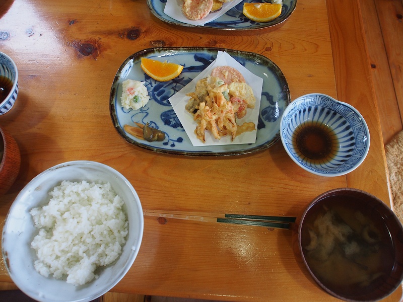 夕食。各種天ぷら、漬物、味噌汁、ポテトラダ、みかんなど。物足りないと感じる方は副菜を持参することをお薦めします。宿泊料金が安いので致し方ないかもしれません。