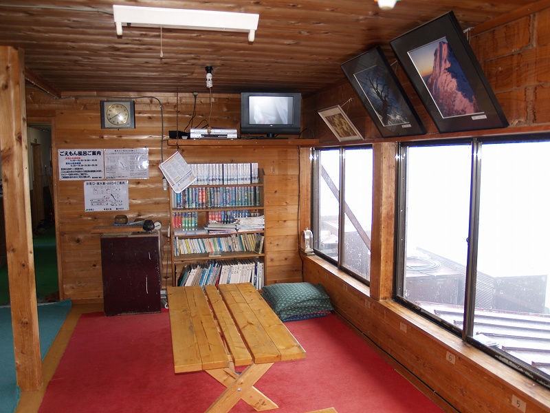 展望良好な談話室。テレビの設置され、本棚には山関係の本や漫画などが多数置かれています。
