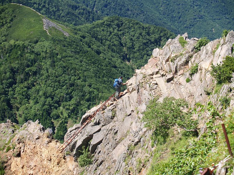 梯子を登り終わった所に立つ登山者。あまり経験の無い登山初心者にとってかなりの高度感を感じる場所です。