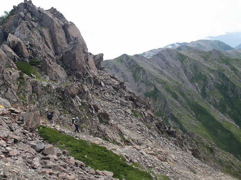 前の写真の岩稜を下る登山者を望遠で撮影。岩稜は巻いています。