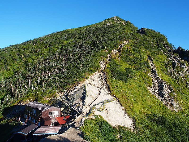 東川岳（背景）と空木岳の鞍部・木曽殿越に建つ木曽殿山荘。比較的小さな山小屋です。